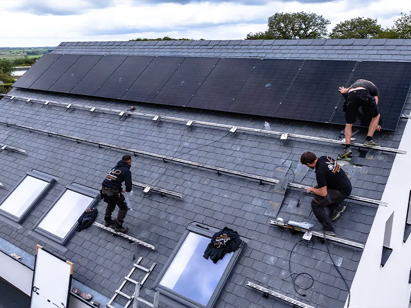 Pose de panneaux solaires par l'équipe JM Photovoltaïque sur un toit en Wallonie